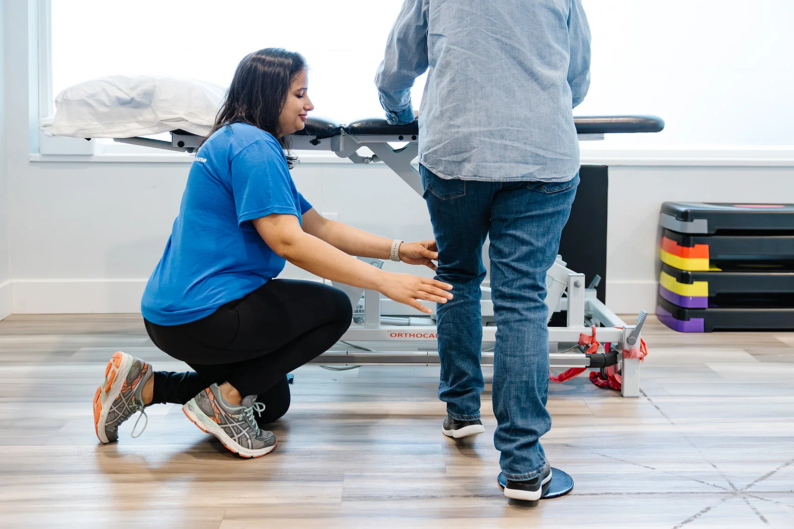 A physiotherapist at Belmont Physiotherapy & Health Clinic assisting a patient during a rehabilitation session.
